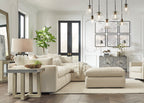 Modern living room with beige sectional sofa, ottoman, and decorative elements.